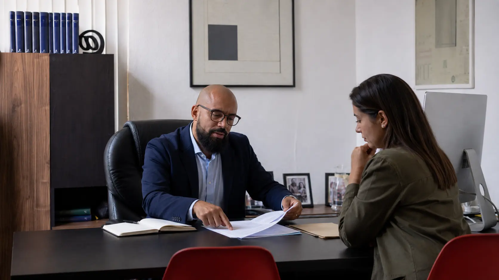 Abogado revisando documentos con una cliente durante una consulta de guarda y custodia